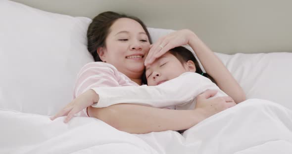 Mother and daughter are sleeping on the bed 2