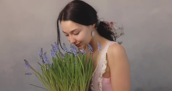 Woman Holding Bouquet of Flowers in Hands Indoors alt