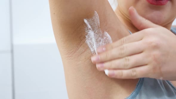 Closeup of Young Woman with Natural Hairy Armpits Applying Shaving Cream Before Removing Hair or alt