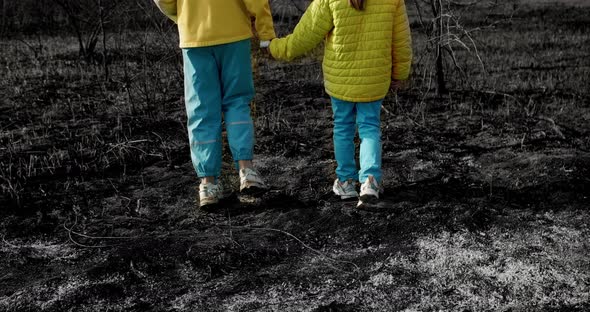 The younger sisters, dressed in the colors of the Ukrainian flag holding hands alt