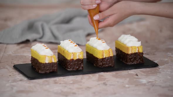 Female Hands Decorate a Sponge Cakes with Apricot Jam From a Pastry Bag