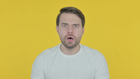 Disappointed Young Man Reacting Loss on Yellow Background alt