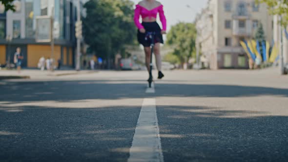 Playful Girl Enjoys Summer and Rides a Scooter Through the Park and City Streets alt