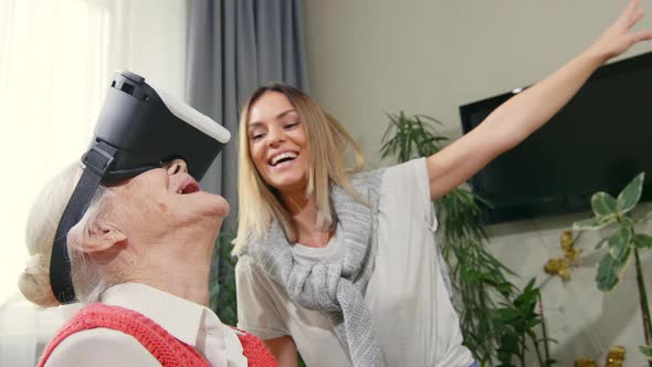 Excited Senior Woman Using VR Goggles with Granddaughter 