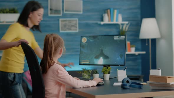 Young Girl Playing Video Games on Computer While Mom Interrupting alt