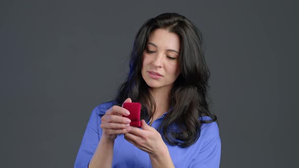 Disappointed Upset Adult Lady, She Doesn't Like Gift - Small Jewelry Box with Marriage Proposal  alt