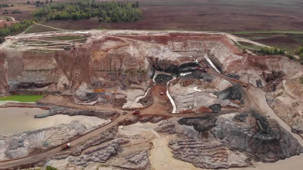 Mining truck is transporting sand at sand quarry. Mining machinery is moving at clay quarry. alt