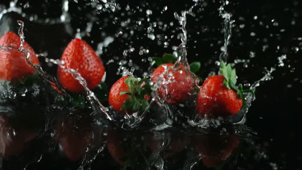 Falling strawberries into a water background. Slowmotion of falling strawberries.
