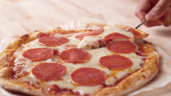 Camera follows a hand picking up a slice of pizza. Slow Motion. alt