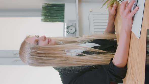 Smiling Woman Working on Computer in Office. Beautiful Young Blond Female Sitting at Workplace with alt