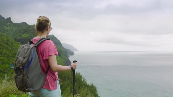 Slow Motion Smiling Woman Hiking By Trail with Cinematic NaPali Hawaii Landscape alt