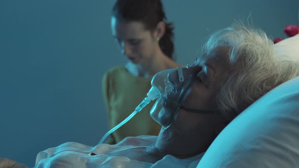 Young woman assisting a senior patient at night