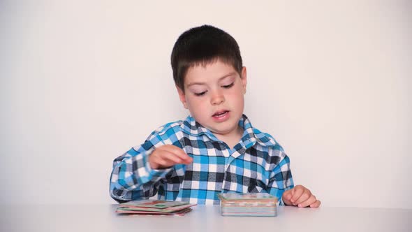 A Boy of 4 Years Old Plays with Cards with Pictures Educational Materials for Preschool Children alt