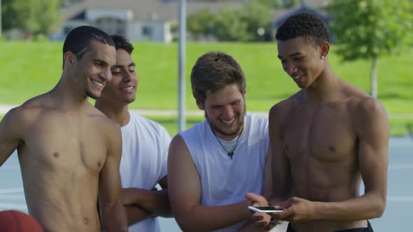 Group of teen basketball players looking at cell phone