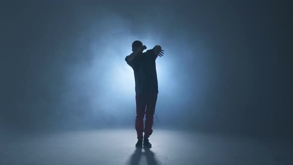Sporty Modern Style Hip-hop Dancer Shows His Dance on Blue Studio Background.
