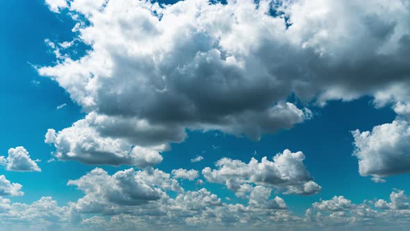 White Fluffy Clouds Slowly Float Through the Blue Daytime Sky Timelapse alt
