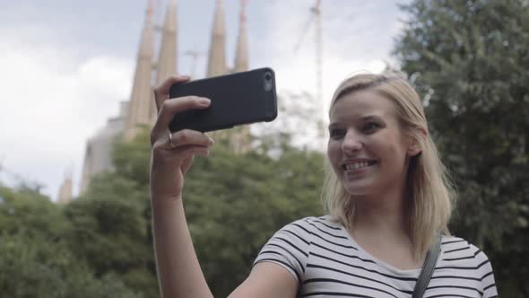 Young adult woman taking selfie on vacation with smart phone