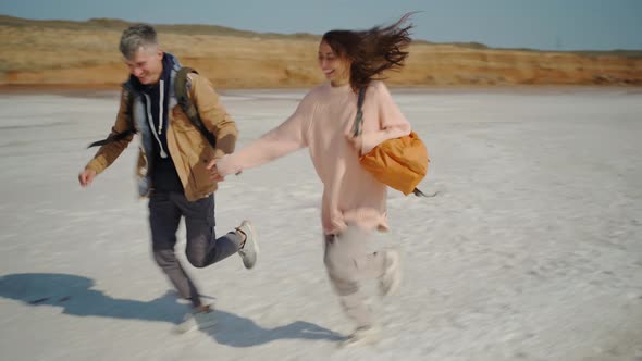 Happy Lovely Couple Millenial Hipsters Walking Hand To Hand and Joyfully Running on Pink White Salty alt