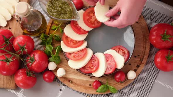 Making Caprese Salad  Putting Sliced Tomatoes and Mozzarella on a Plate alt