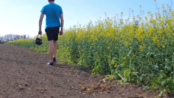 The Athlete is on the Flower Field with Bike Helmet alt