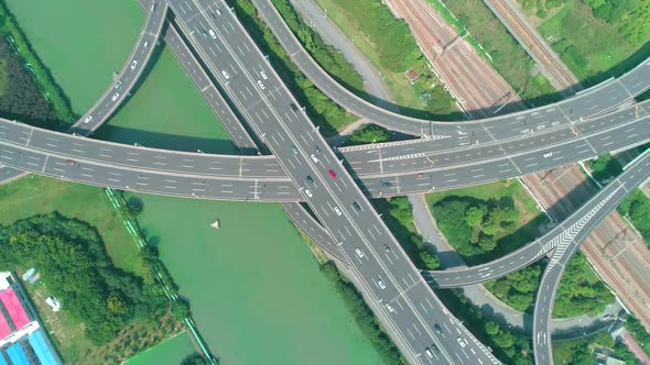 Aerial Top Down View of a Highway Overpass Multilevel Junction with Fast Moving Cars Surrounded By alt