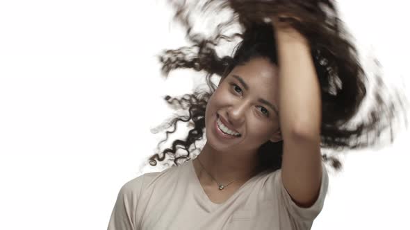 Closeup of Beautiful and Sassy Darkskinned Woman Showing Her Curly Hairstyle Whiping Hair and alt