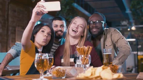 Friends making selfie with mobile phone and grimacing