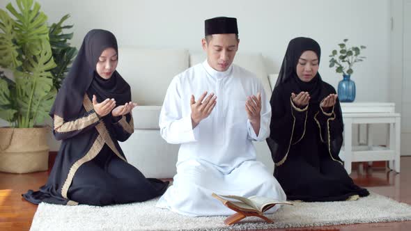 Young Islamic people praying with reading the Quran