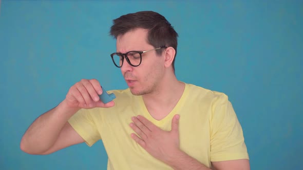 Middle-aged Man in Glasses and T-shirt Asthma Attack,uses Spray alt