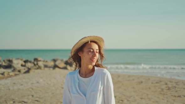 Portrait of Beautiful Stylish Woman Traveler Walking Along Sea Coastline and Enjoying Sunset at alt