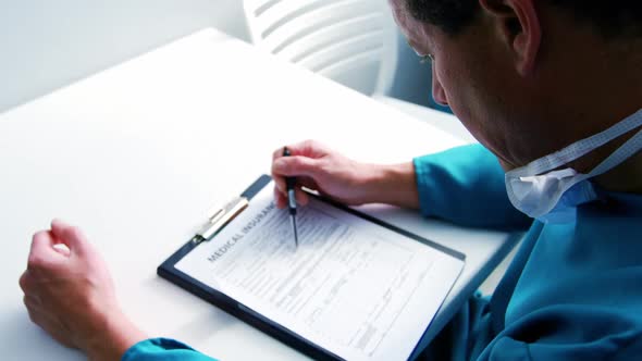Doctor filling medical insurance form alt
