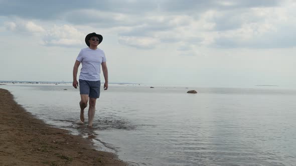 Adult Man Walking Along Sea Shore