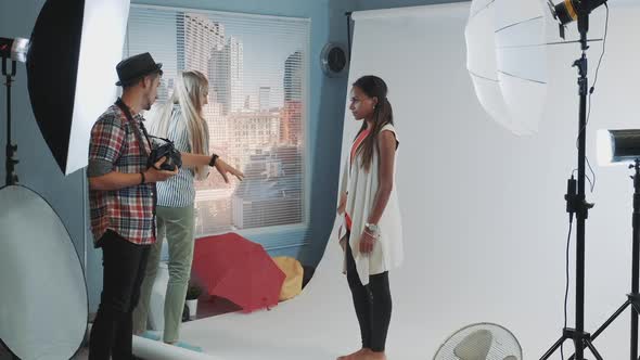 Behind the Scenes on Photo Session Assistant Giving Model a Bar High Chair