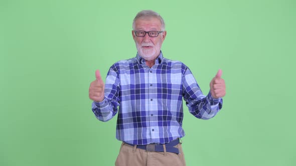 Happy Senior Bearded Hipster Man Giving Thumbs Up and Looking Excited alt