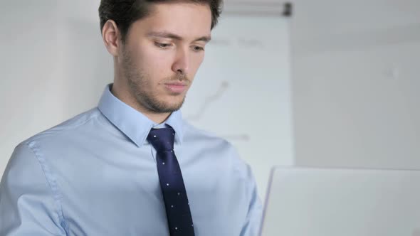 Close Up of Young Businessman Working on Laptop alt