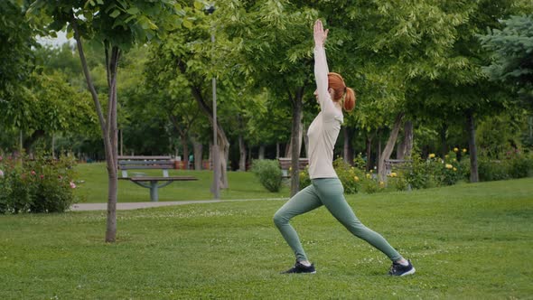 Caucasian woman practices yoga outdoors. alt