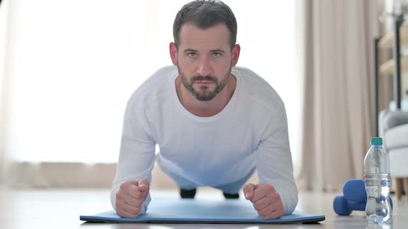 Close Up of Strong Man Doing Plank on Yoga Mat at Home alt