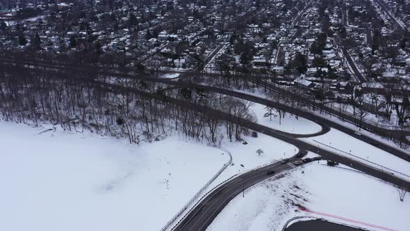 An aerial view from a drone, over a frozen lake during sunrise on a cloudy morning. The camera tilte alt