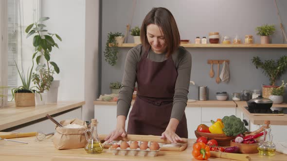 Woman Rolling Dough in Kitchen alt