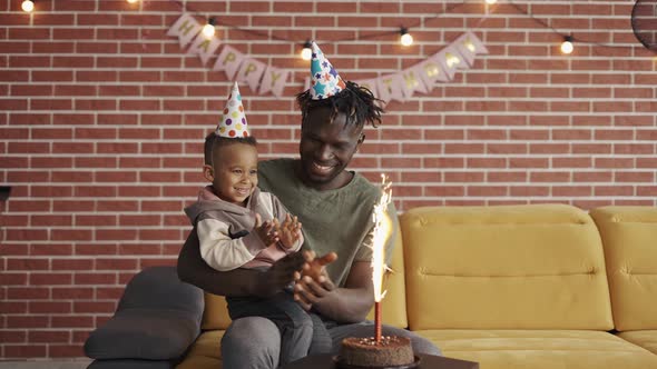 African American Smiling Father Celebrating Son's Birthday alt