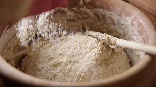 BAKING - Sprinkling flour on the batter, sourdough bread, slow motion close up alt