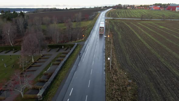 Man Skiing Down Long Wet Countryside Road Near Ostersund, Sweden. 4K Drone. alt