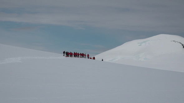Antarctica Peninsula.  People hikers climbing mountain, team work, travelling, trekking. alt