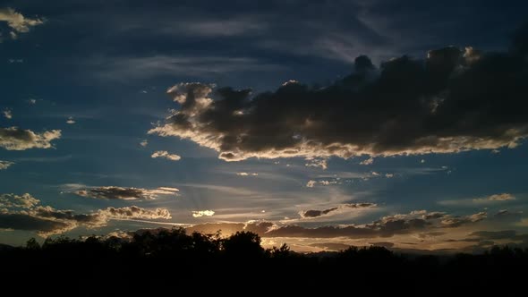 Sunset with birds flying across the sun and Flatirons alt