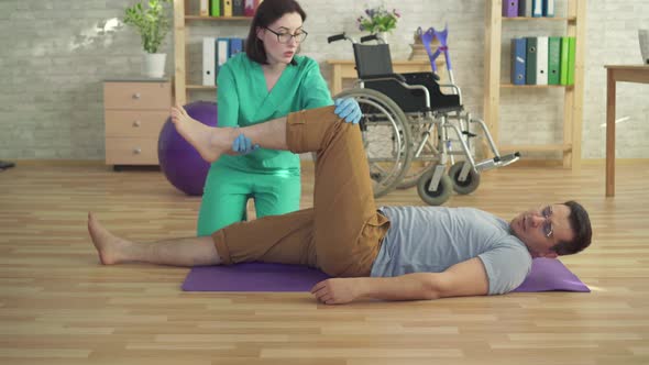 Physiotherapist Helps a Man To Do Recovery Exercises alt