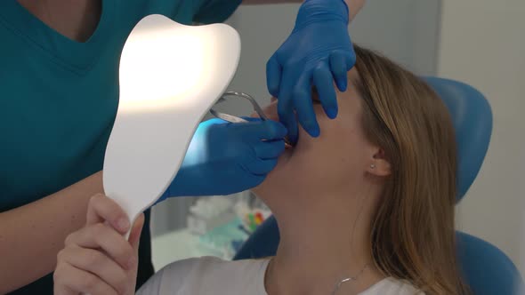 Orthodontist Puts Rubber Rods on Patient's Braces alt