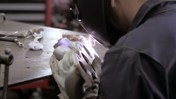 Welding Process. Worker Doing Welding Job. A Man In Helmet Doing Argon Welding Parts 