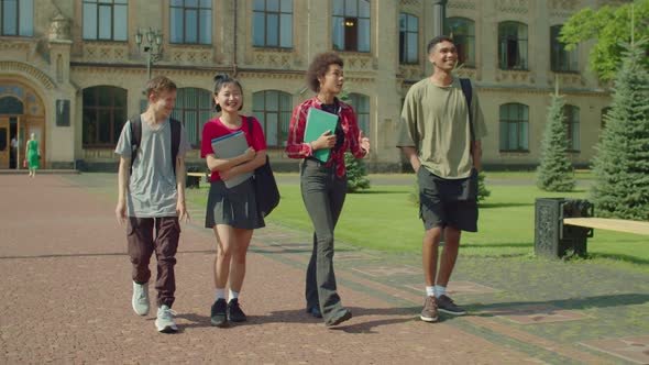 Happy Diverse Multiracial College Students Walking After Lecture at Campus alt