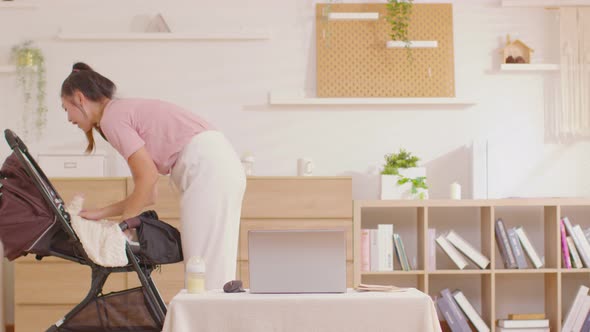 Timelapse of busy Asian mother woman holding her baby newborn and working together staying at home. alt