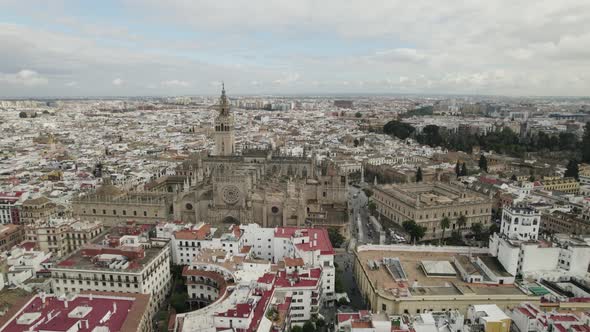 Main facade of Seville Cathedral, sprawling charming cityscape. Aerial view